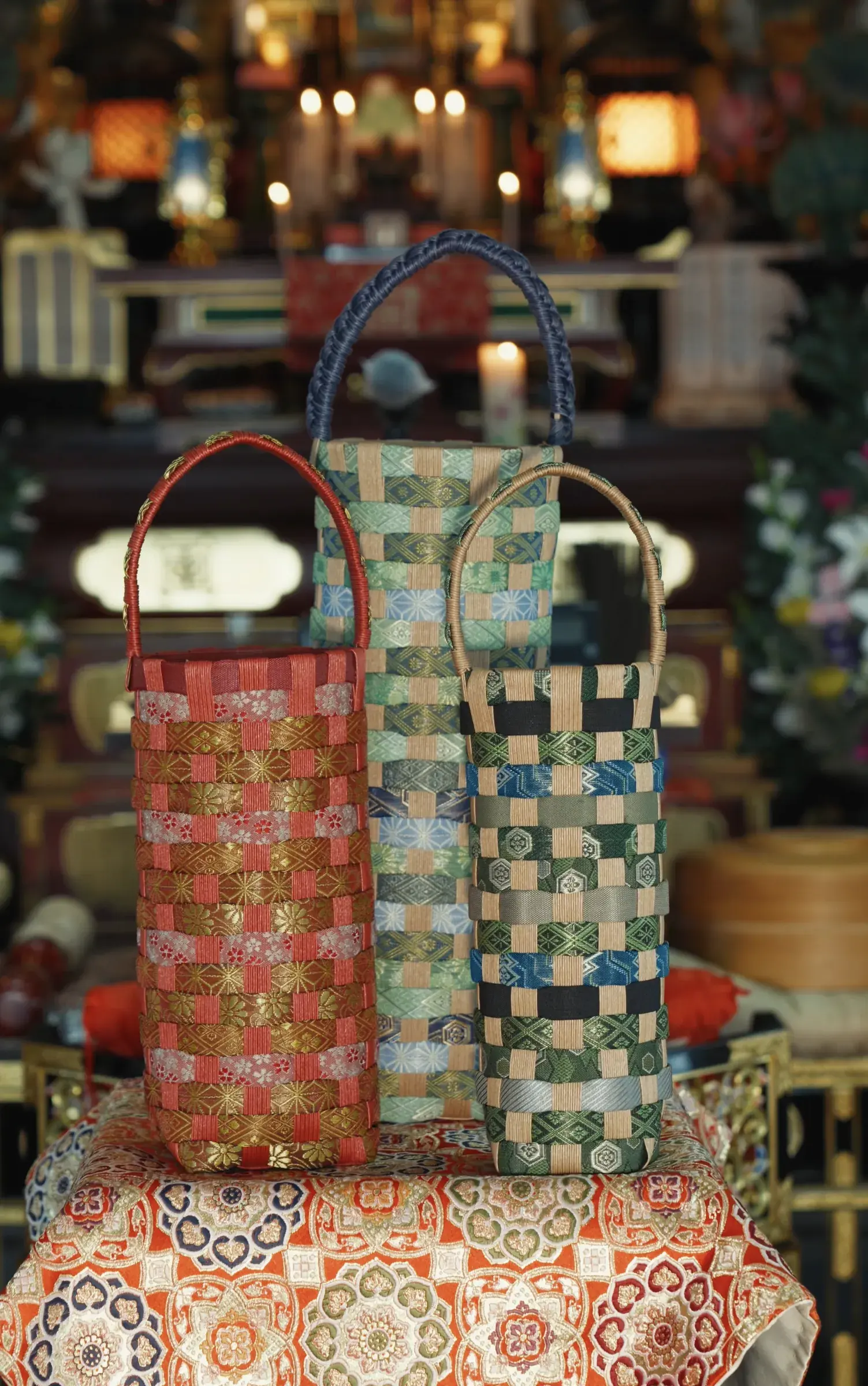 Three bottle bags standing on brocade before the altar of the main hall