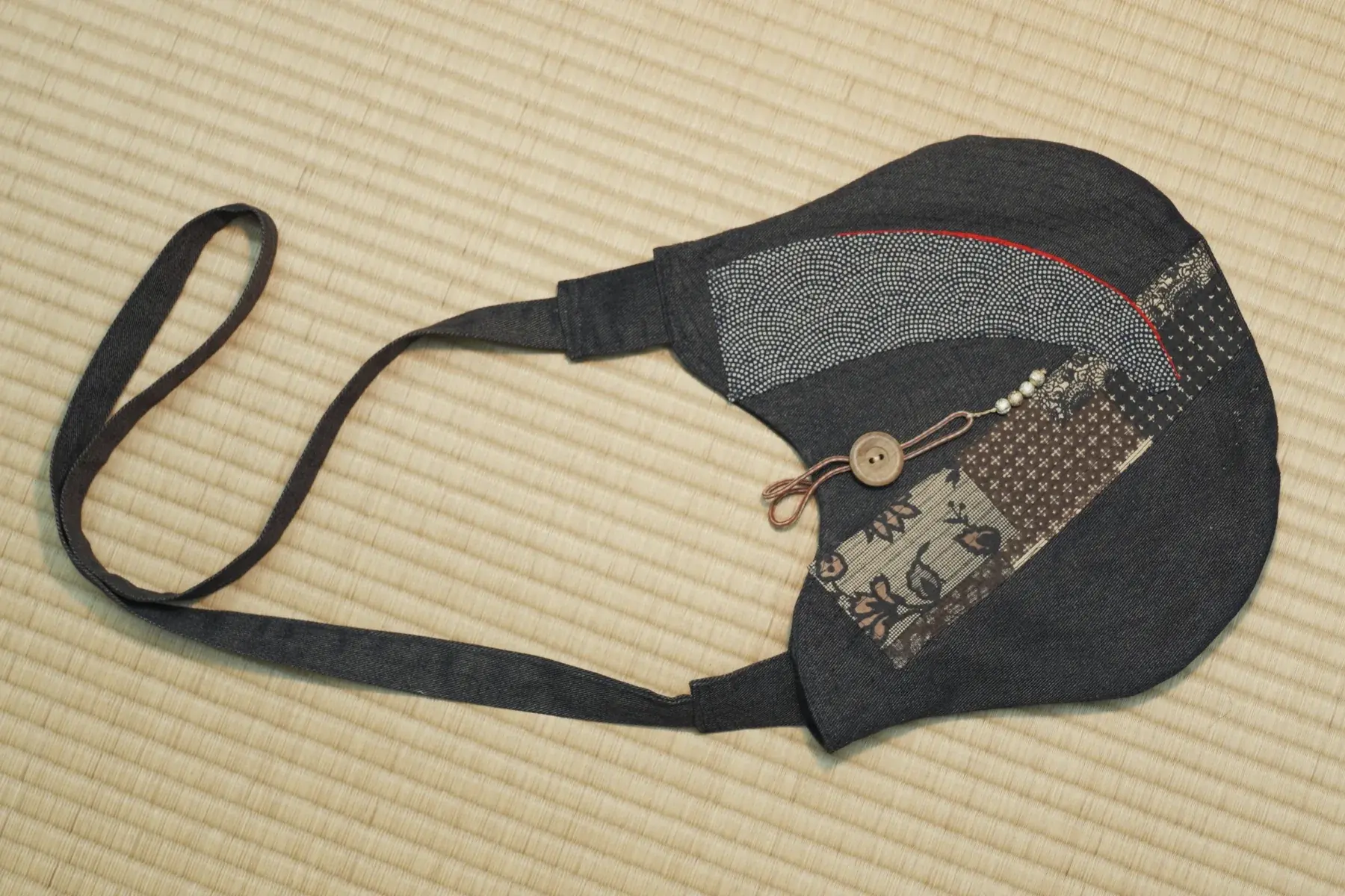 Kon — Indigo with a patchwork of small prints, closed by a wooden button.