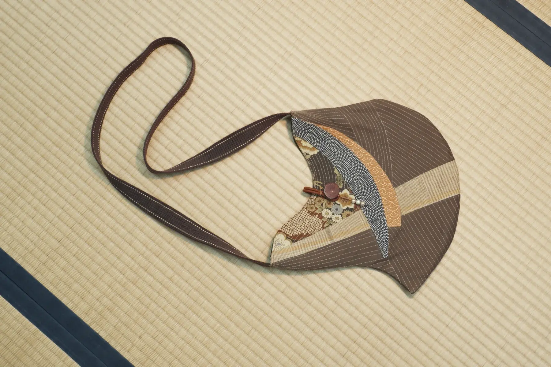 Kurumi — Walnut brown pieced with slate blue and sand, with a brown strap.