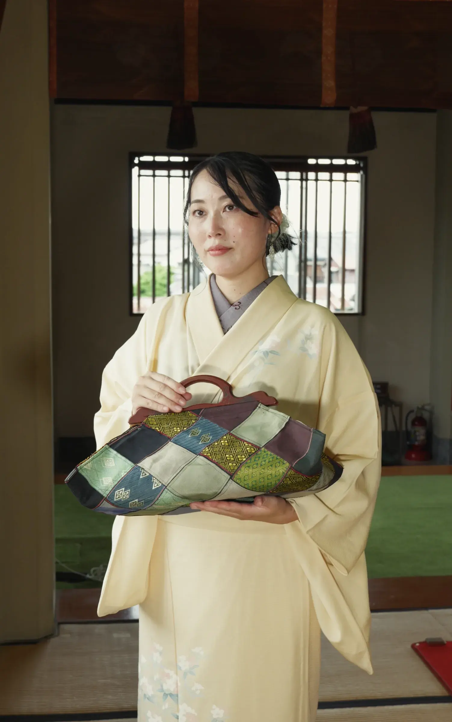 In the temple hall, holding the Hishi handbag